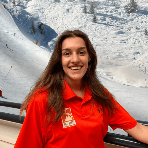 Alt tekst: Jong meisje in rood ski- of snowboardoutfit met sneeuwlandschap op de achtergrond, binnen bij Ski-Mere.