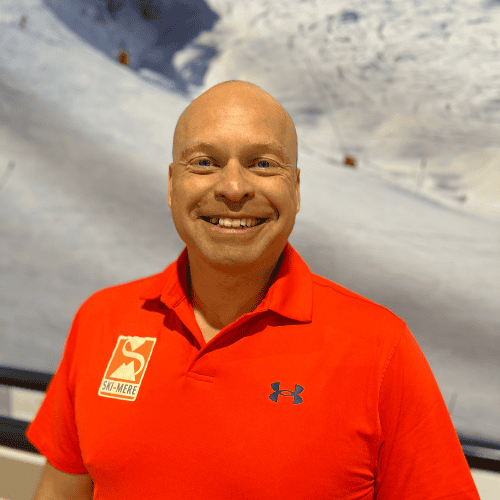 Ski-instructeur in een rode skidervaring shirt voor een indoor skibaan in Almere.